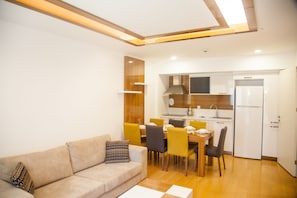 A modern living room with a sofa and a dining area with chairs and a table.