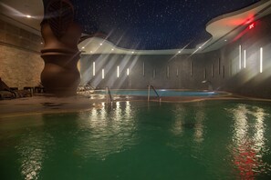 A swimming pool with a starry ceiling, a large sculptural piece, and modern lighting. - Taraklı Termal Suite (Tarakli)