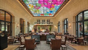 A spacious lobby with a high ceiling, large windows, and a central seating area with sofas and tables. - Mandarin Oriental Lutetia, Paris (Paris)