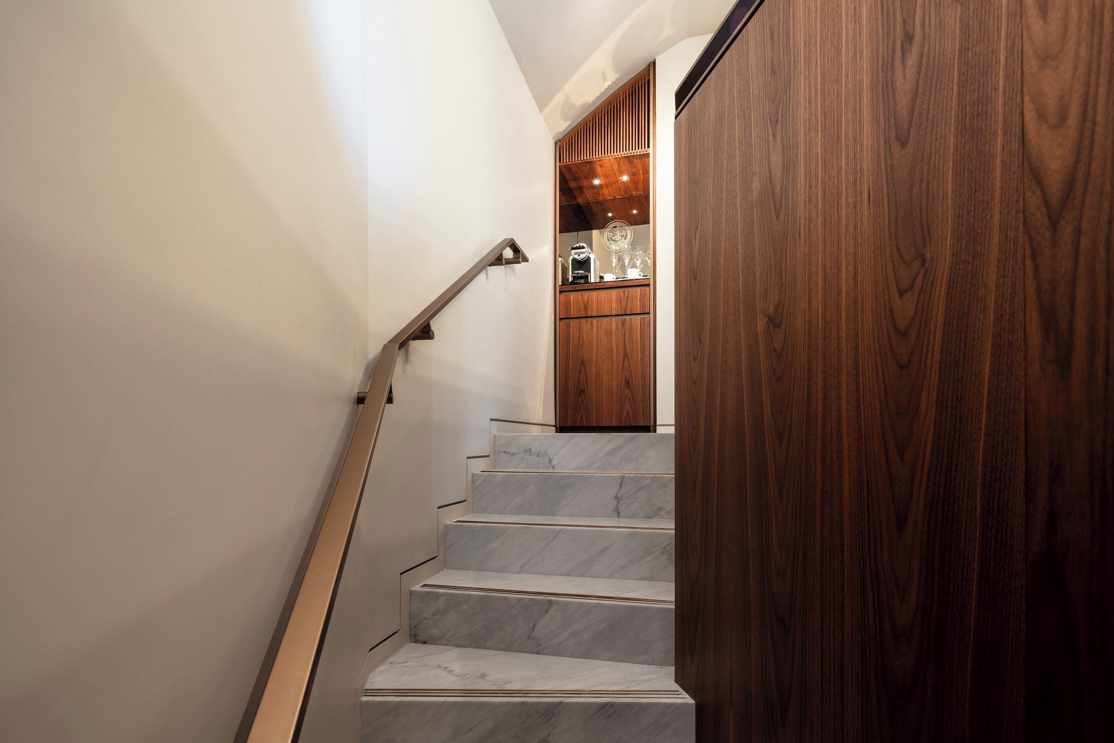 A staircase with marble steps leading to a wooden door.