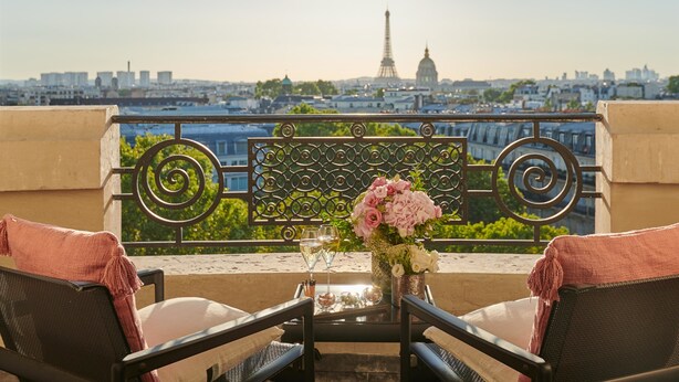 A balcony with a view of the Eiffel Tower, a table with a vase of flowers, and two chairs. - Mandarin Oriental Lutetia, Paris (Paris)