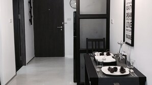 A dining area with a table set for two, a clock on the wall, and a framed inspirational quote. - Stay in Style The Heart of Nimman R208 (Chiang Mai)