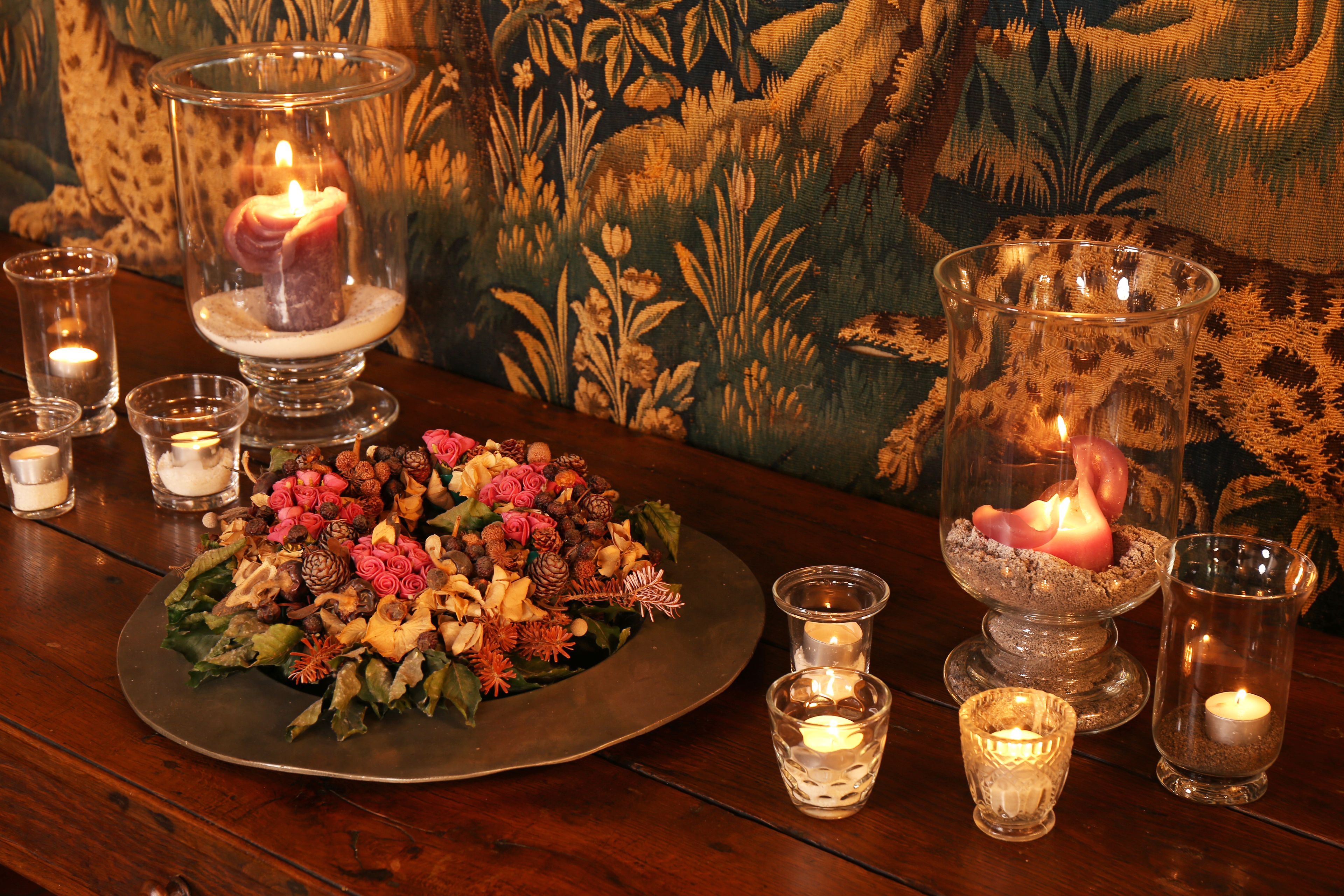 Una mesa con un centro de mesa floral, velas y candelabros de cristal.