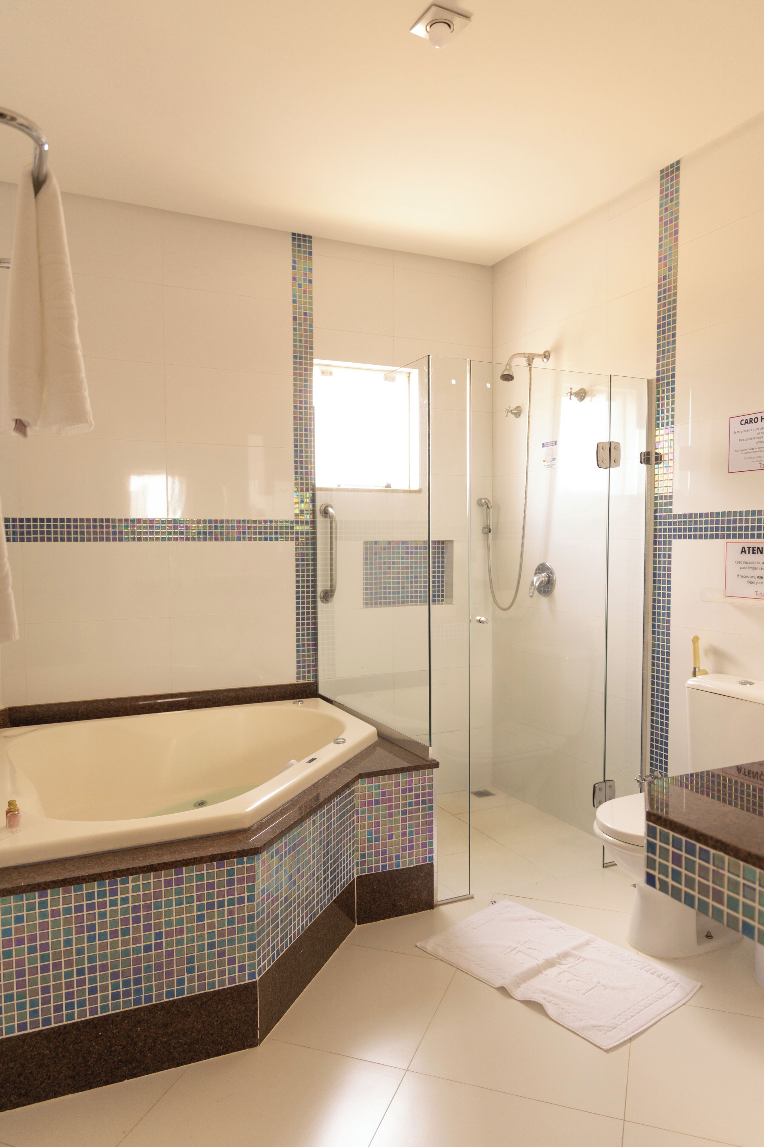 A modern bathroom with a glass-enclosed shower, a freestanding bathtub, and a tiled floor.