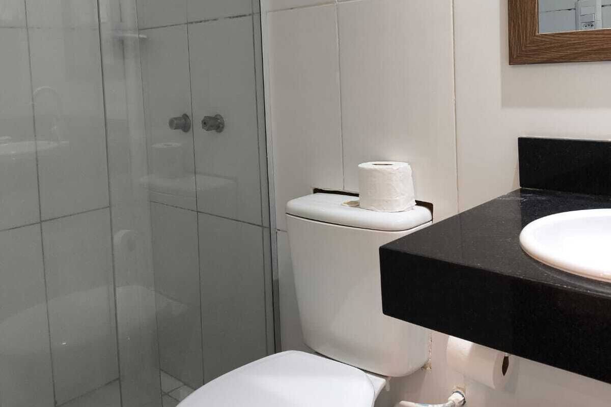 A bathroom with a toilet, a sink, and a shower.