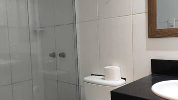 A bathroom with a toilet, a sink, and a shower.