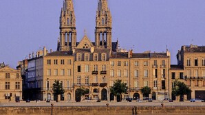 A historic building with two prominent towers, a central entrance, and a series of windows.