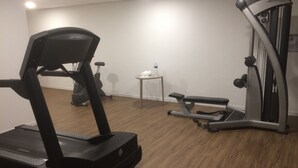 A home gym with a treadmill, elliptical, and bench.