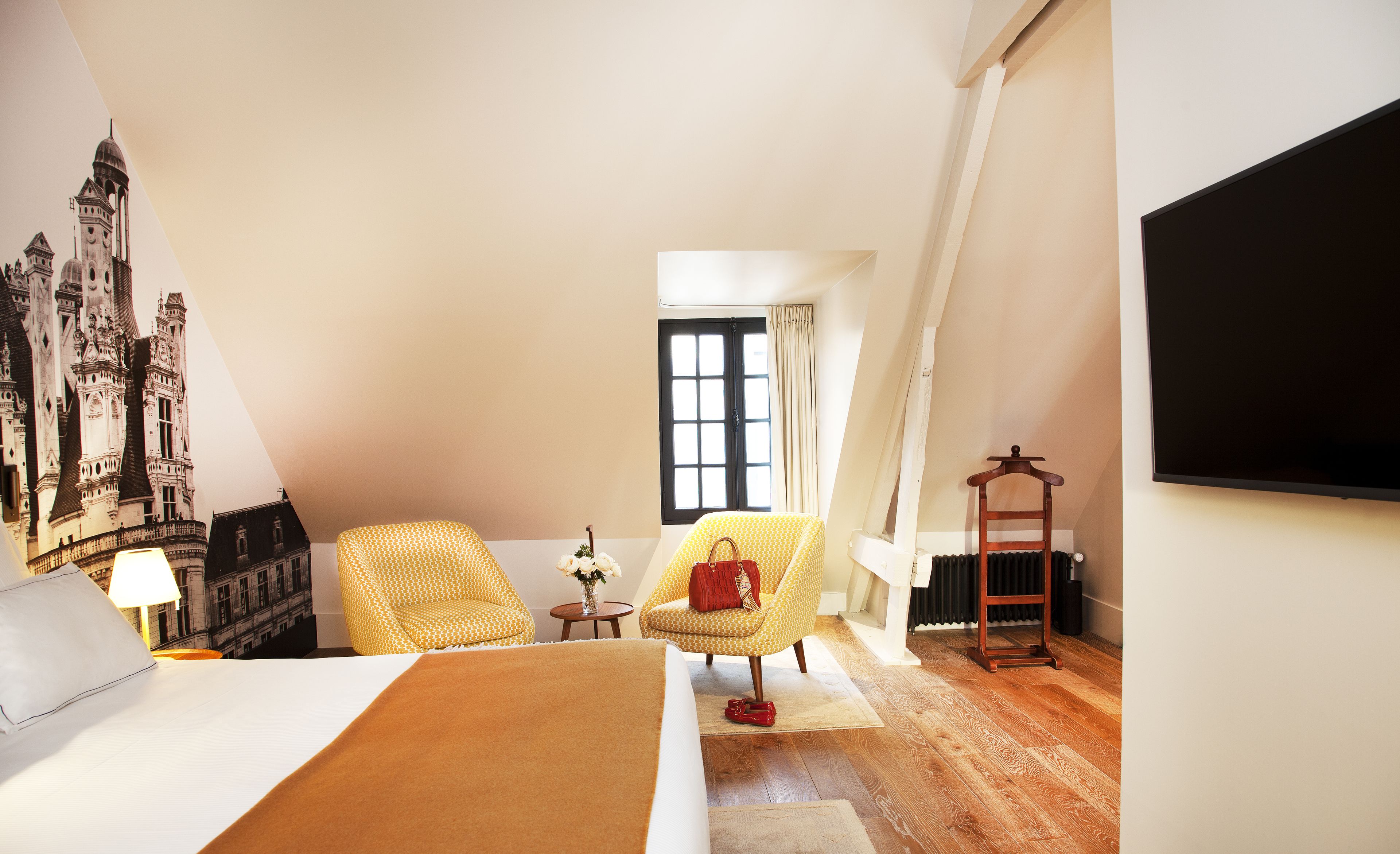 A room with a bed, a chair, a radiator, and a window.