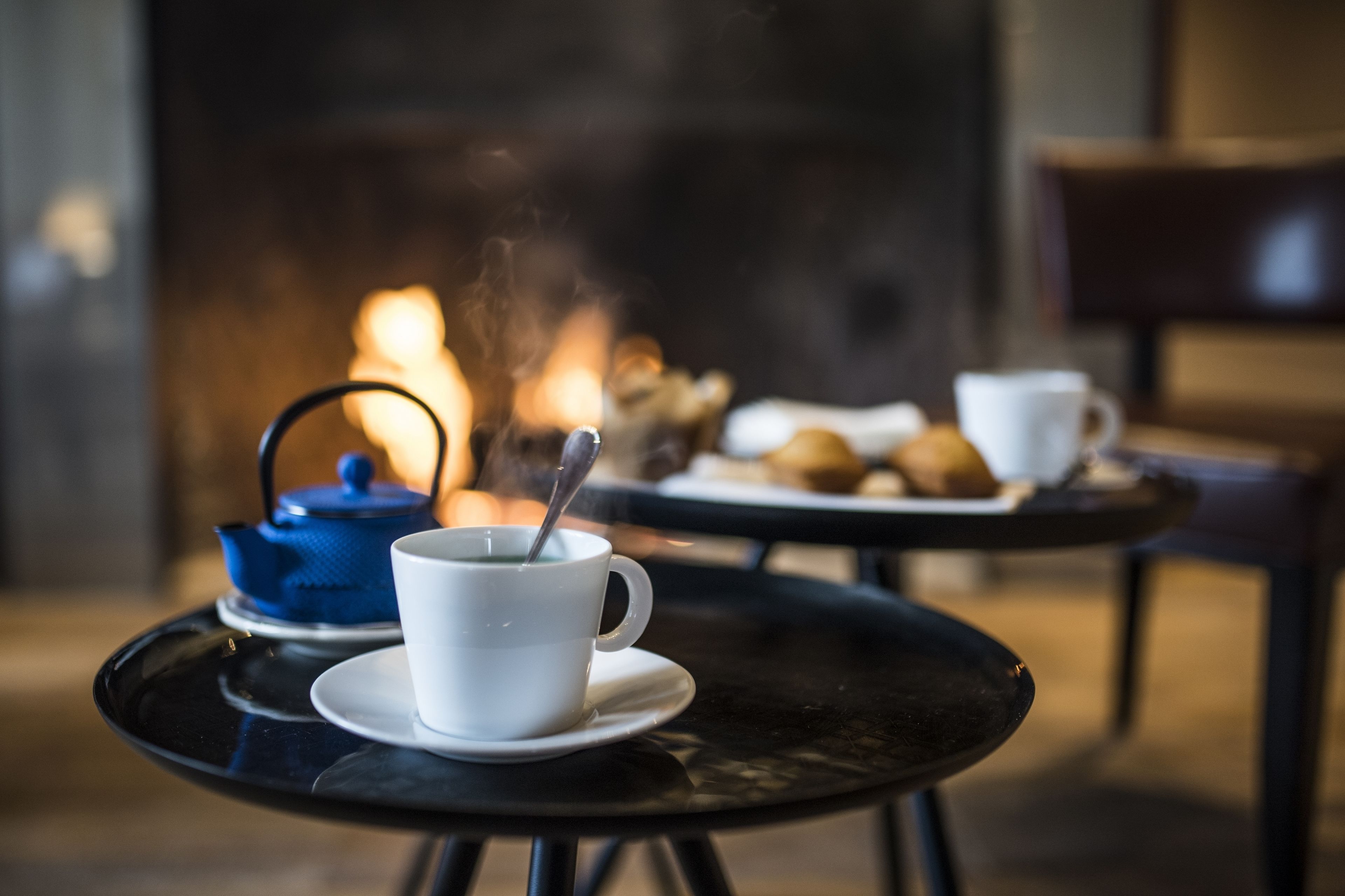 Un ambiente acogedor en el interior, con una mesa preparada para tomar té, una tetera y una taza con cuchara.