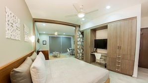 A bedroom with a bed, a desk, a TV, and a wardrobe. - Splendid 1 bedroom by Happy Address (Playa del Carmen)