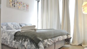 Una cama bien hecha con una colcha estampada de flores y un edredón doblado.