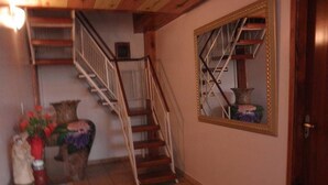 A staircase with a wooden handrail and a white railing, leading to an upper floor. - Pousada LN (Caldas Novas)