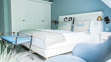 A bedroom with a bed, a chair, a nightstand, and a wardrobe.