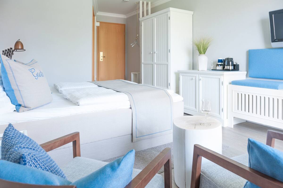 Een moderne slaapkamer met een bed, een klein tafeltje en een babybedje.