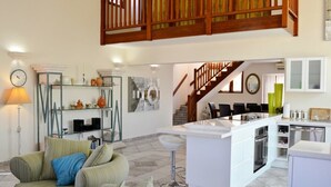 Un vaste espace de vie comprenant un canapé, une table basse et un îlot de cuisine.