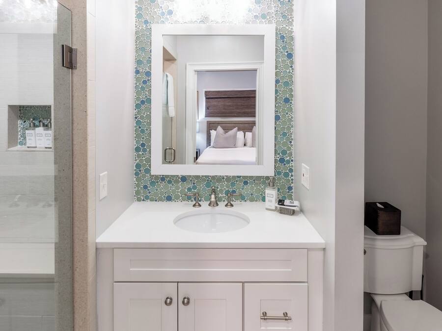 A bathroom with a white sink, a mirror, and a toilet.