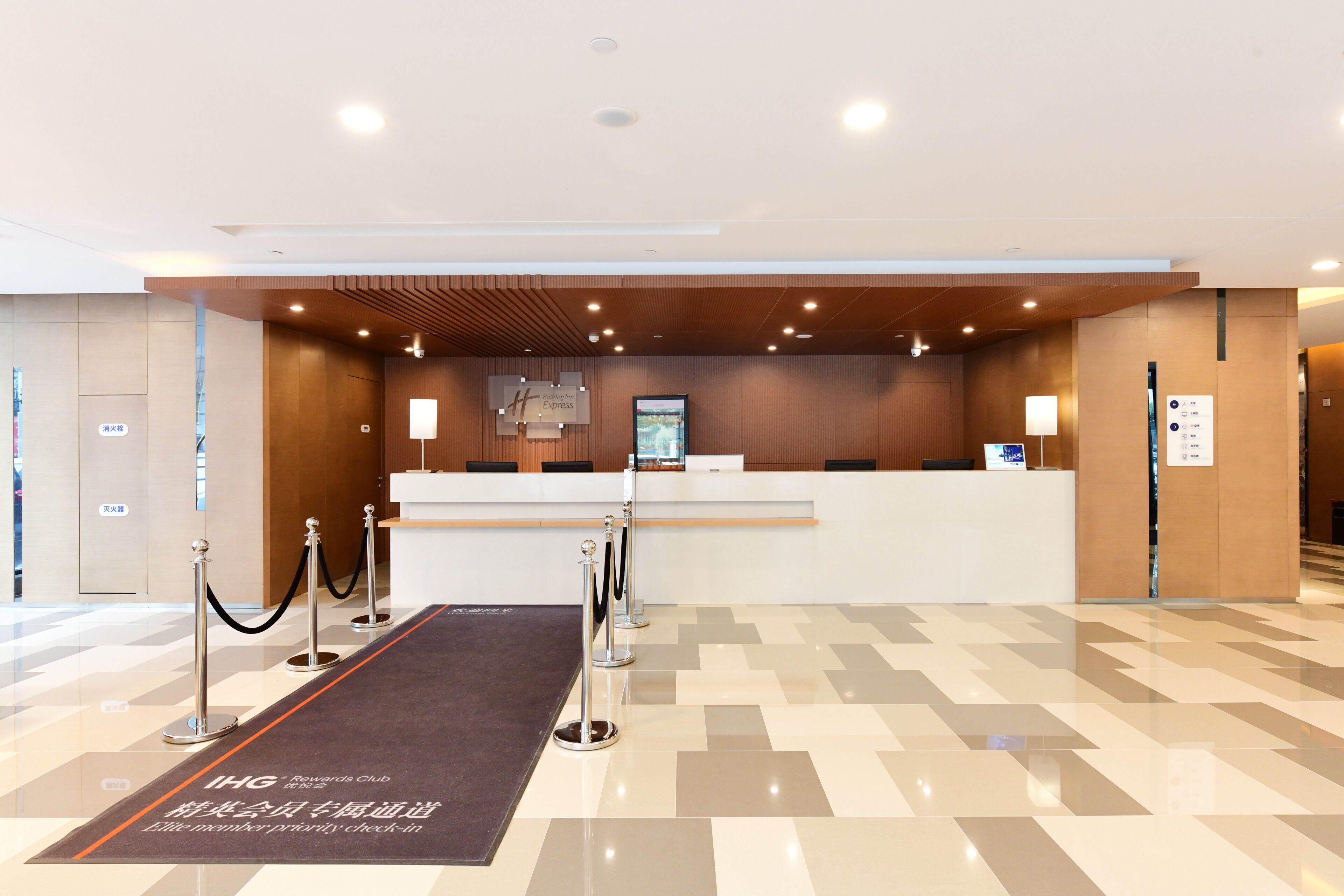 A hotel reception area with a check-in desk, a digital display, and a VIP lounge sign.