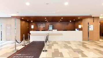 A hotel reception area with a check-in desk, a digital display, and a VIP lounge sign.