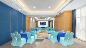 A conference room with blue tables and chairs, a large screen, and a carpeted floor. - Holiday Inn Express Chengdu Xindu by IHG (Chengdu)