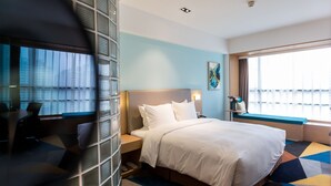 A hotel room with a bed, bedside table, lamp, and a window with a view. - Holiday Inn Express Chengdu Xindu by IHG (Chengdu)