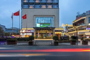 A hotel with a modern facade, large glass windows, and a prominent entrance with steps.