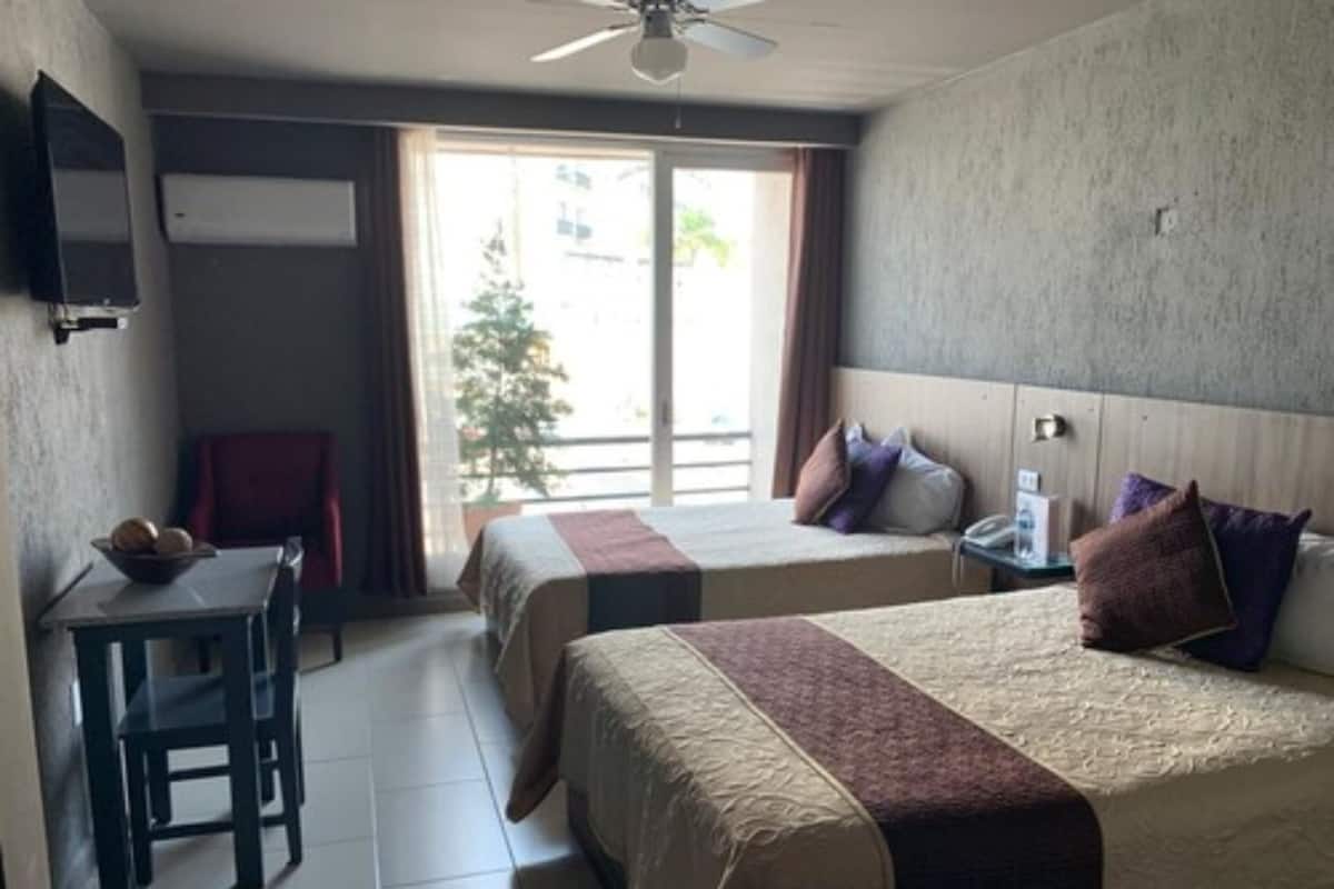 Habitación doble, 2 camas matrimoniales | Escritorio, tabla de planchar con plancha, wifi gratis y ropa de cama