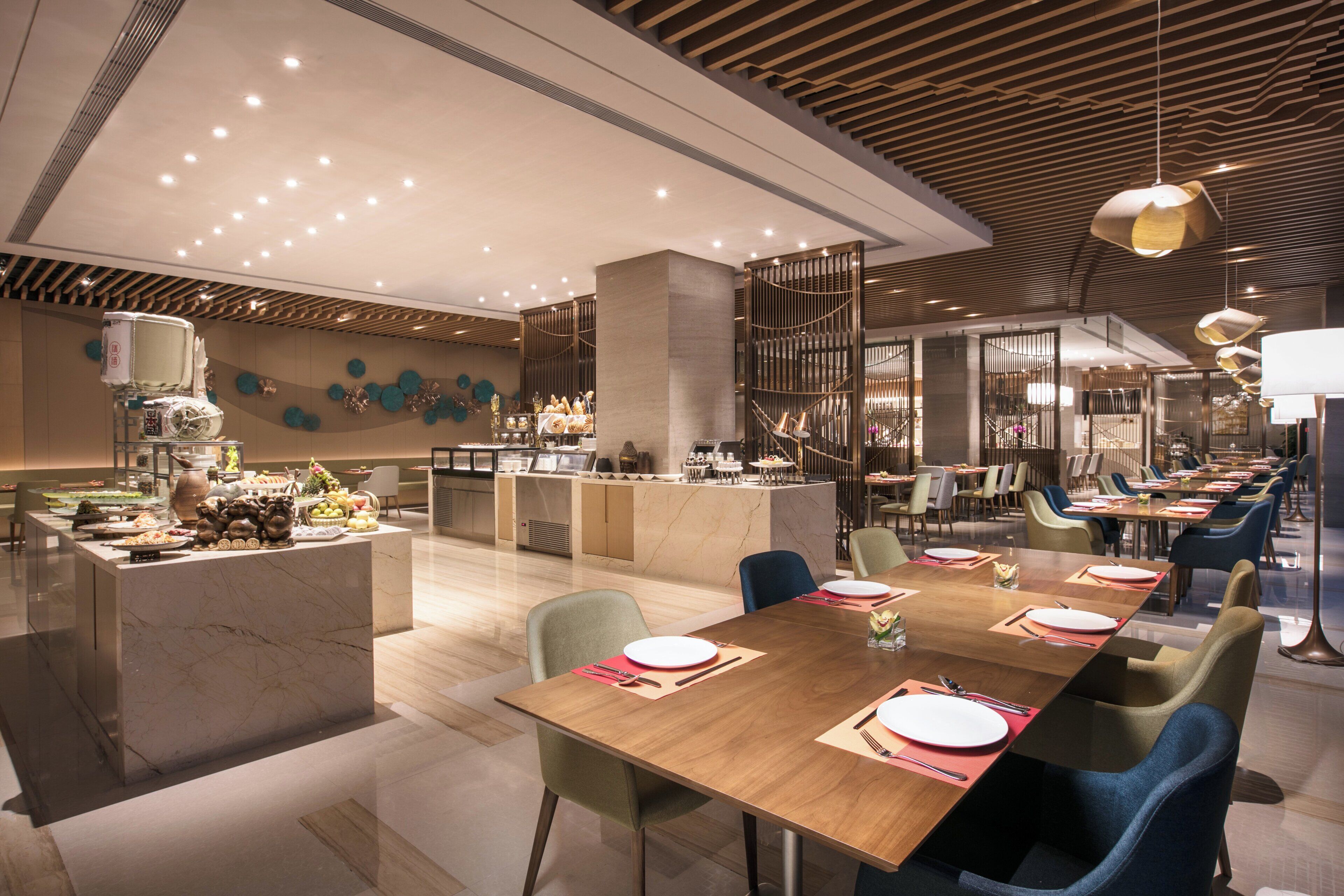 Un ristorante moderno con un'area bar centrale, diversi tavoli e varie opzioni di posti a sedere.