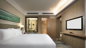 A hotel room with a large bed, a television on the wall, a mirror, and a bathroom visible through an open door. - Holiday Inn Hangzhou Gongshu by IHG (Hangzhou)