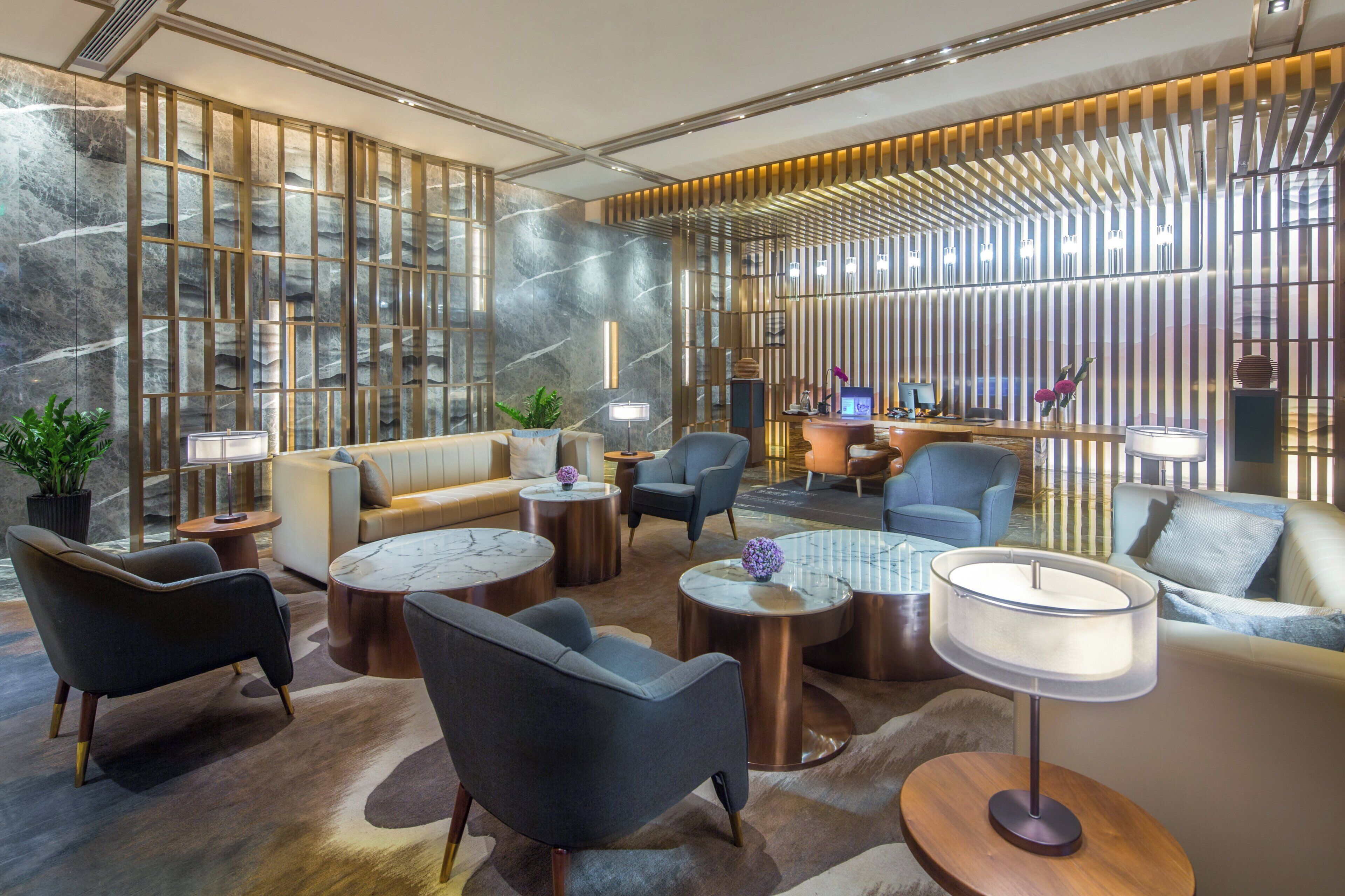 A modern lounge area with seating, tables, and a decorative wall.