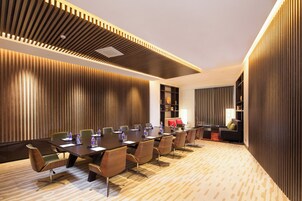 A conference room with a long table, chairs, and a sofa.