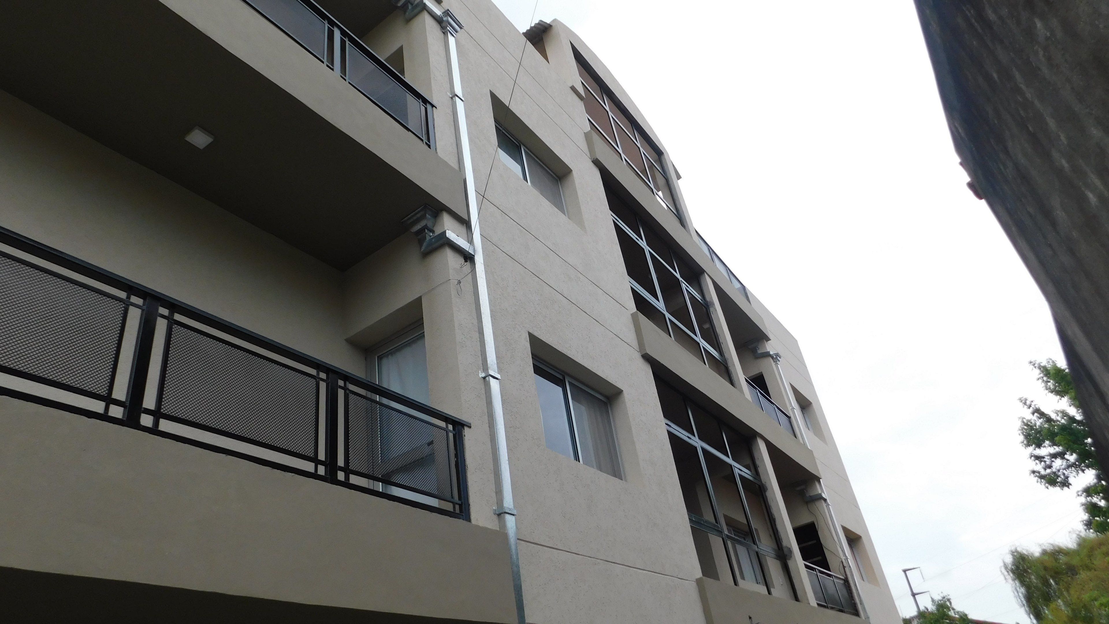 Un edificio de varios pisos con balcones, ventanas amplias y una fachada plana.