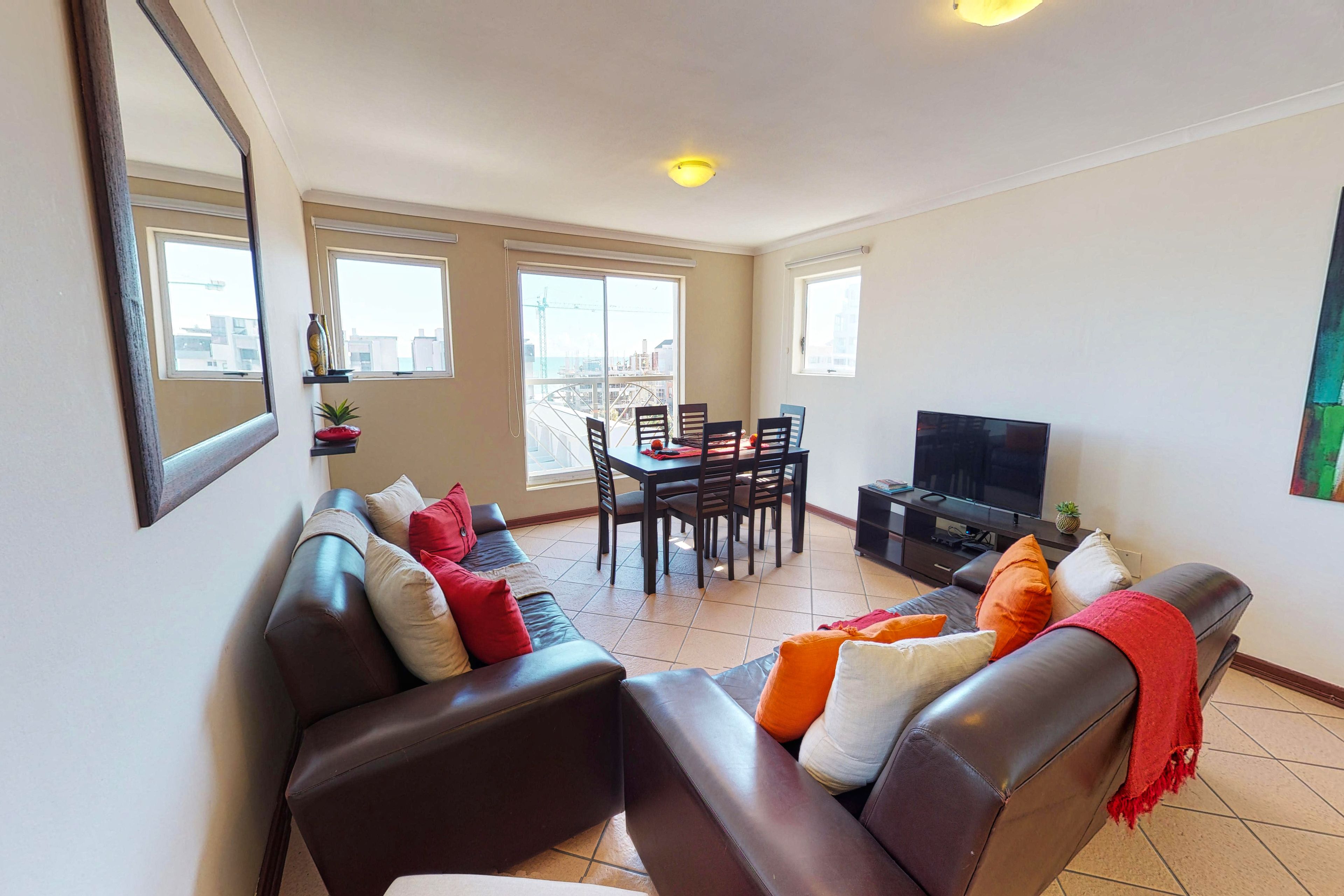 A living room with a sofa, TV, and dining table.
