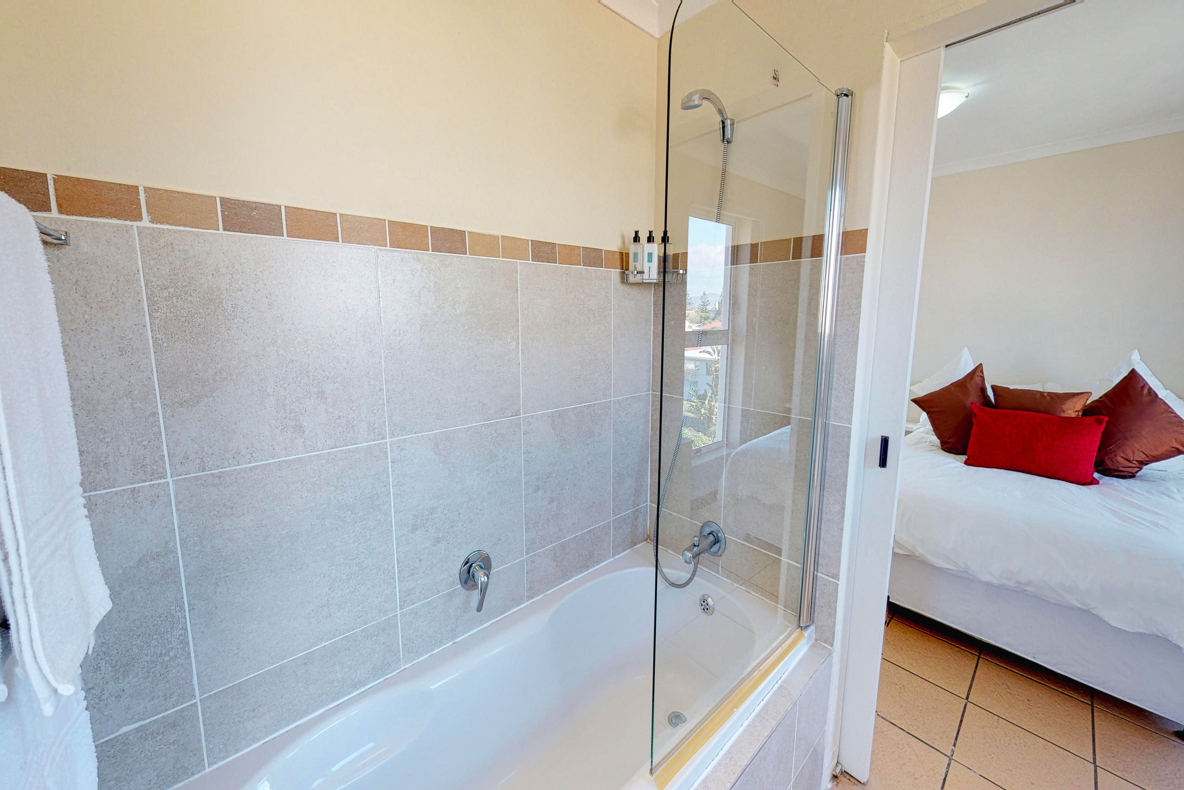 A bathroom with a bathtub, shower, and glass-enclosed shower area.