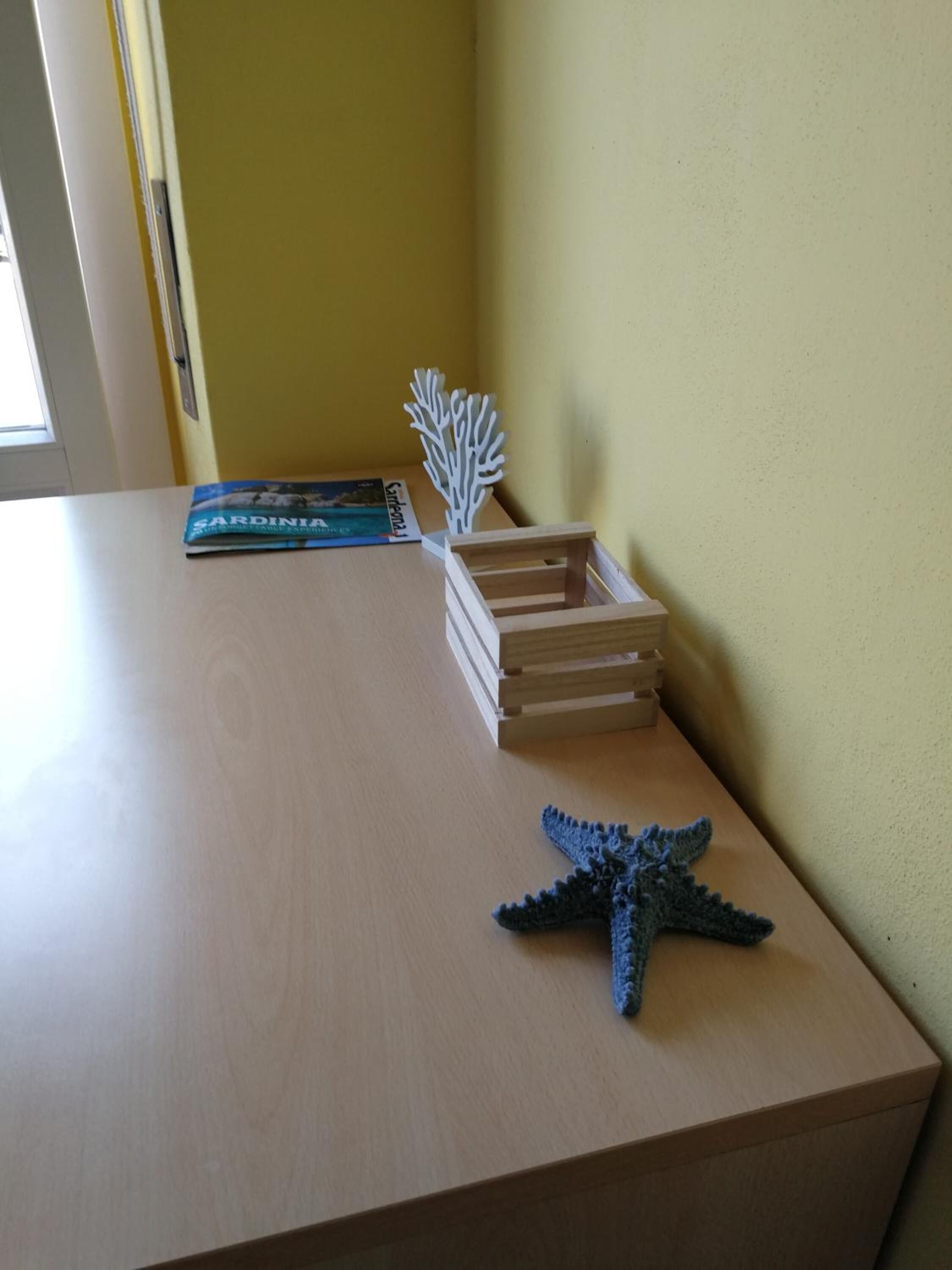 Una mesa de madera con un libro, una estructura de madera y una estrella de mar.