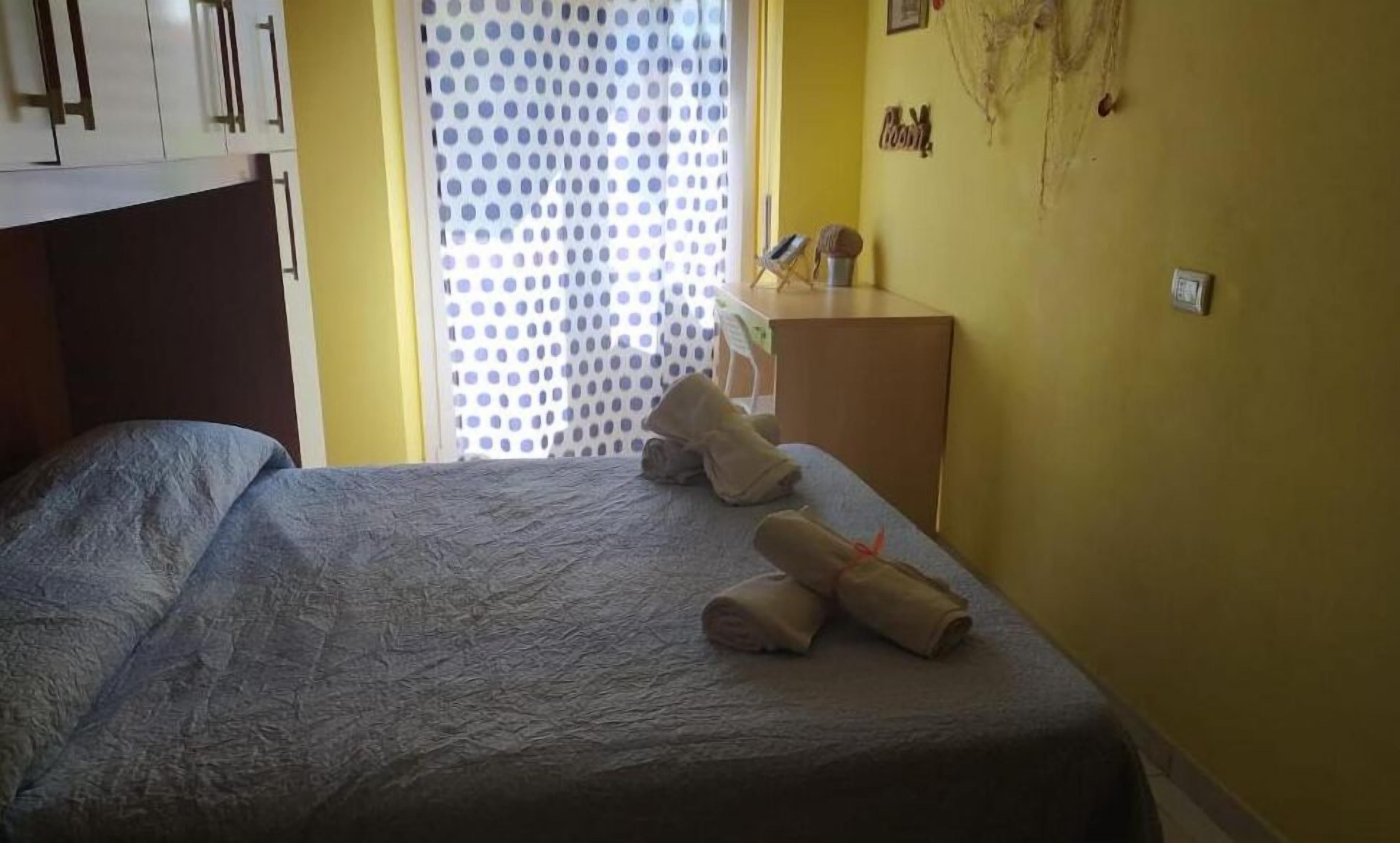 A room with a bed, a desk, and a curtain with a polka dot pattern.