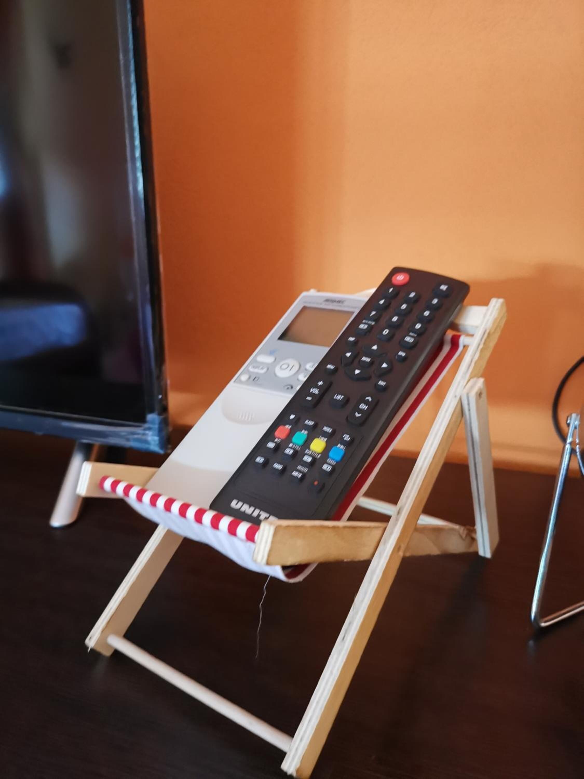 A small wooden stand with a remote control on it.
