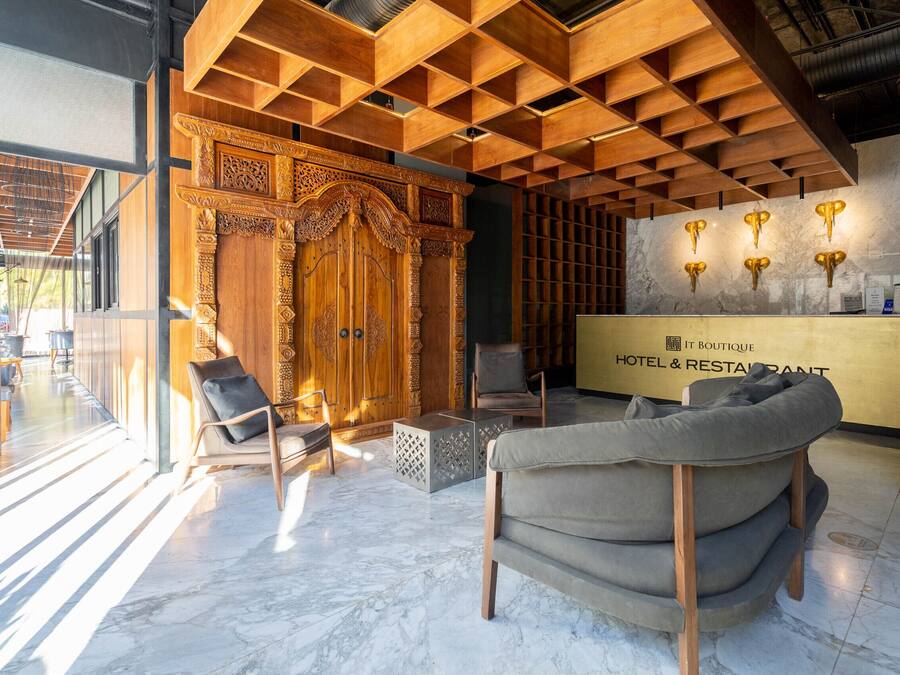 Una hall d'hotel con una reception in legno, un divano e una parete decorata.