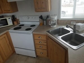 Standaard cottage, 1 queensize bed met slaapbank, privébadkamer, uitzicht op jachthaven | Privékeuken | Een koelkast, een microgolfoven, een oven, een kookplaat