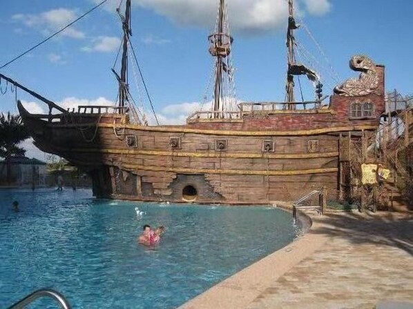 A pirate ship-themed pool with a wooden deck and a lifebuoy.