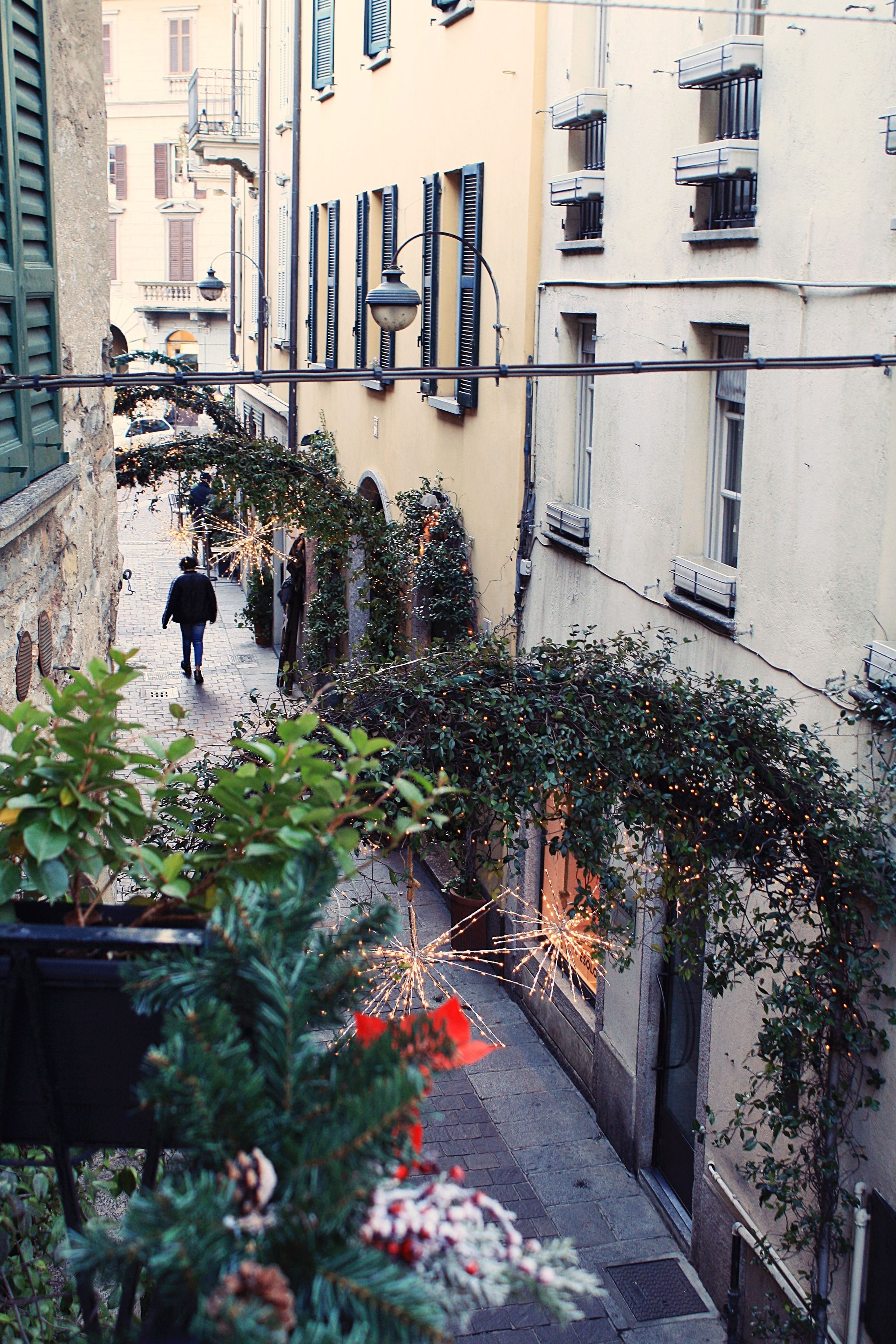 Un estrecho callejón flanqueado por edificios, con balcones y ventanas.