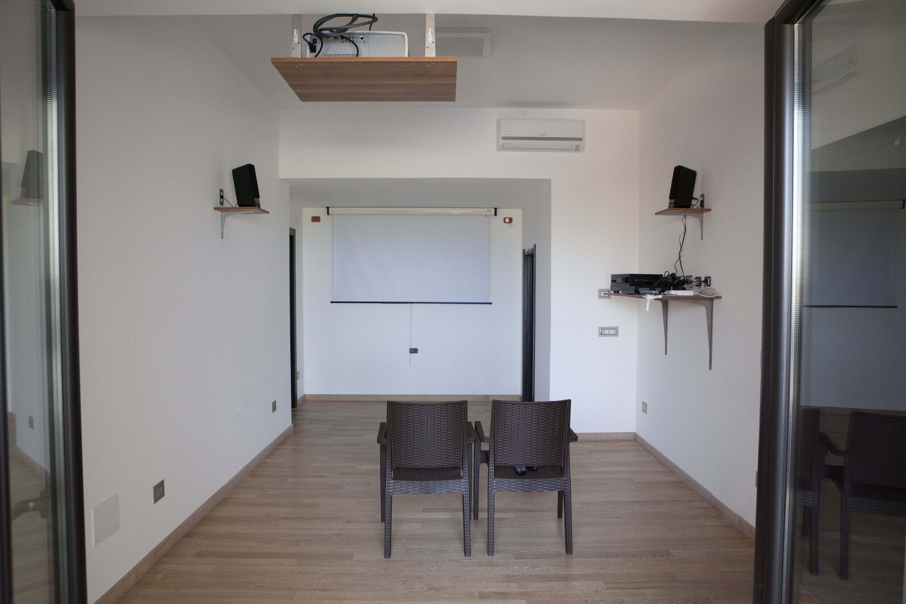 Une salle de conférence équipée d’un tableau blanc, de deux chaises et d’une table.