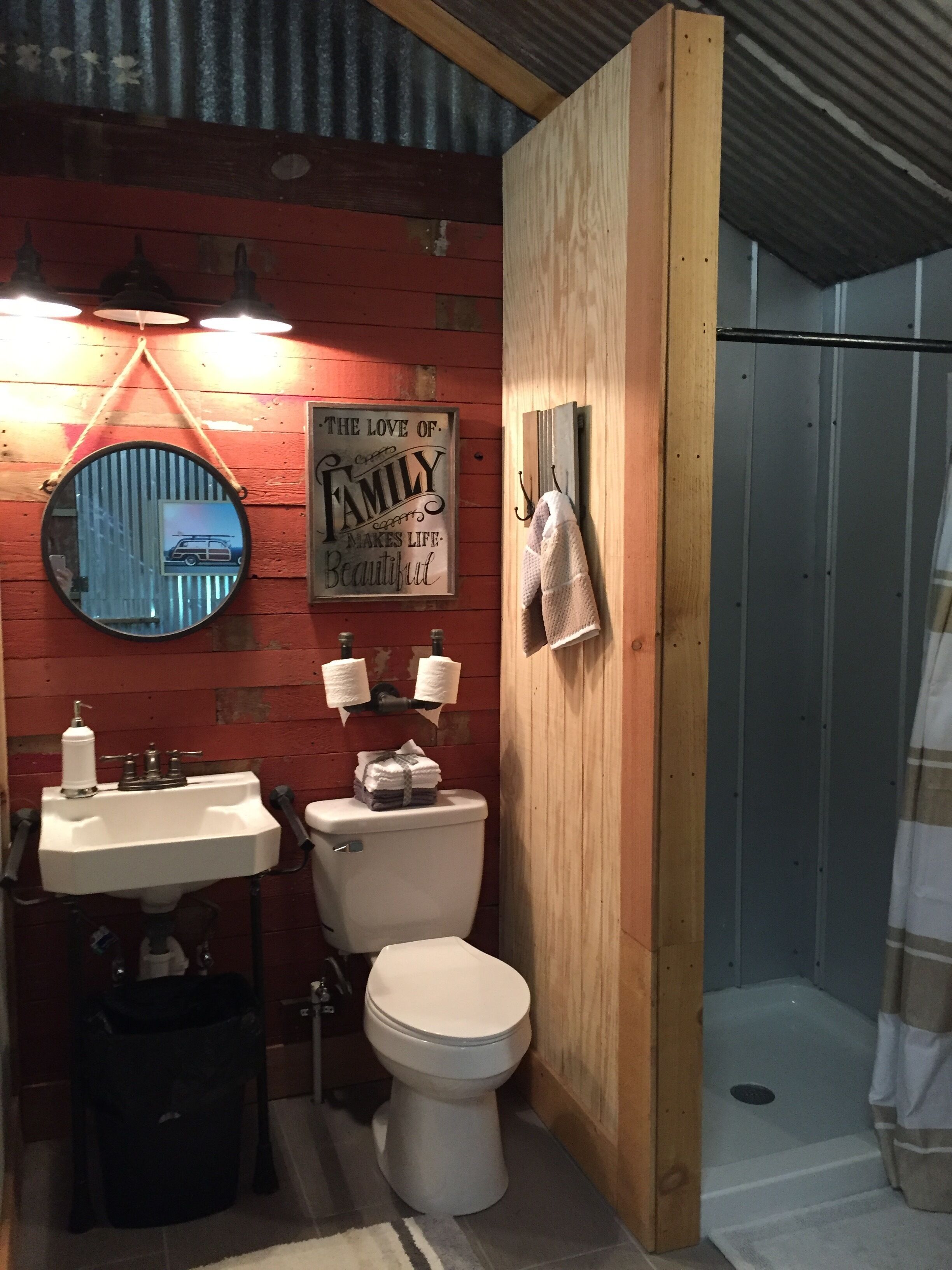 A compact bathroom with a wooden vanity, a toilet, and a shower.
