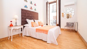 A bedroom with a bed, a nightstand, a lamp, a chair, and a wall with pictures. - MADRID-SOL-GATE PLAZA MAYOR, New Apartment, Comodo, modern design. (Madrid)