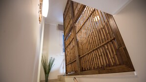 A staircase with a bamboo screen and a plant on the landing. - San Vito Lo Capo with style and relaxation .. (San Vito Lo Capo)