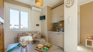 A modern kitchen with a dining area, a sofa, and a table with food. - San Vito Lo Capo with style and relaxation .. (San Vito Lo Capo)
