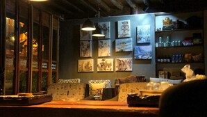 A cozy room with a wooden table, cushioned seating, and a wall adorned with framed artwork.