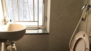 A bathroom with a toilet, a sink, and a window. - Capital Guesthouse (Kowloon)