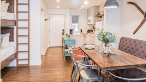 A compact kitchen with a dining table, chairs, and a bench. A ladder is against the wall, and there is a window above the sink. - Outpost: Pitchfork 2303 - Close to Snow King Mtn! (Jackson)