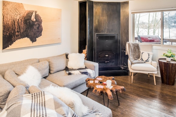 A living room with a sofa, a fireplace, and a chair.